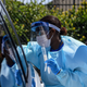 Medical personnel administer tests at a “drive-through” testing center in West Palm Beach, 75 miles north of Miami, in March 2020.
